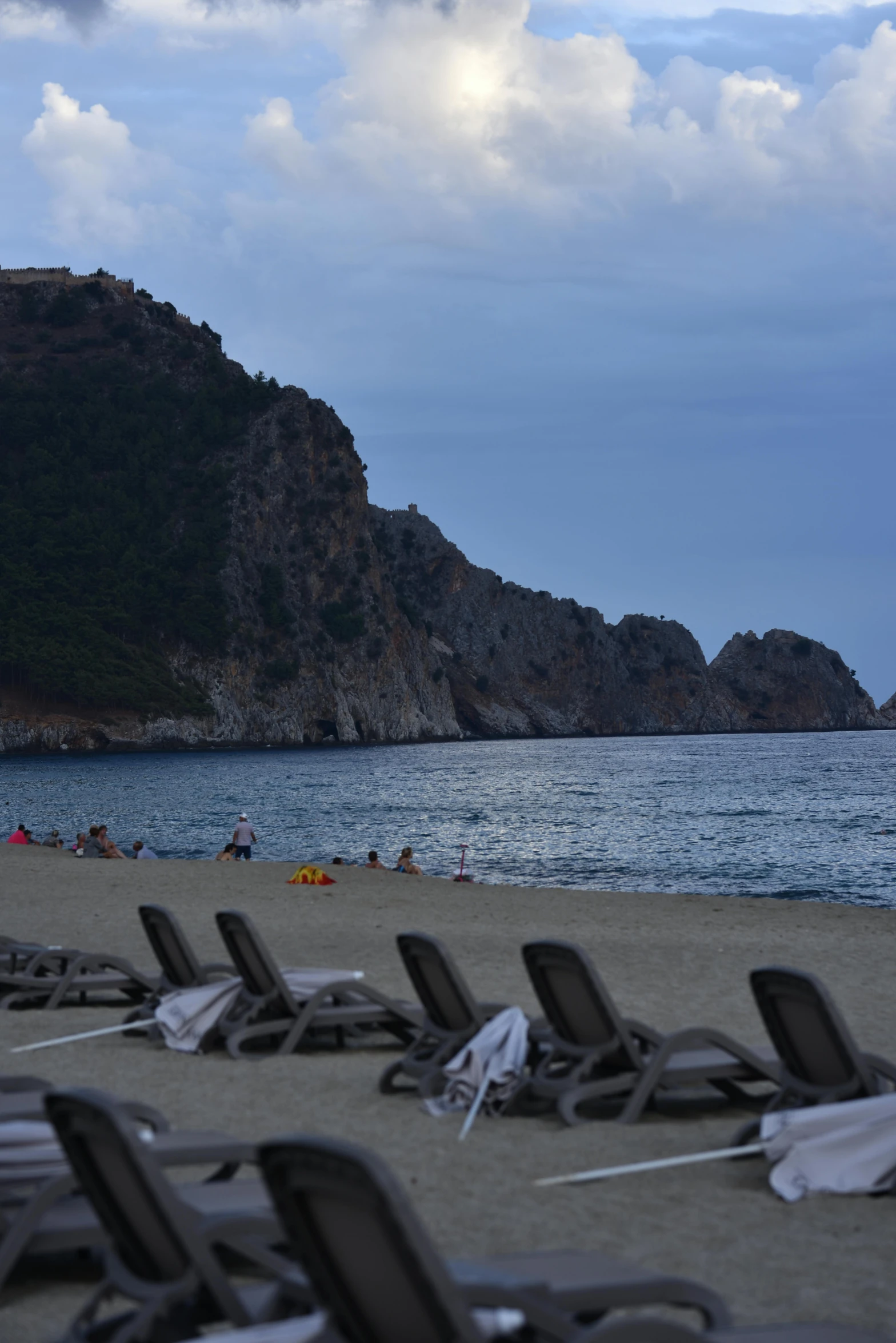 some black chairs are next to a hill and water