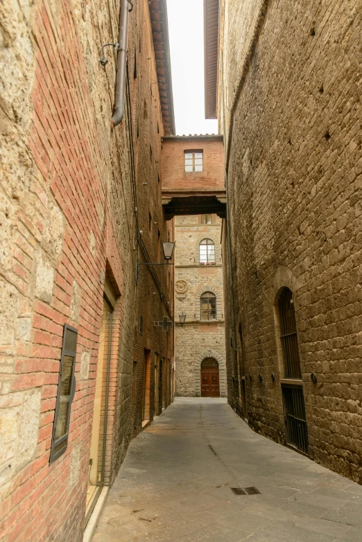 a narrow alley way with a fire hydrant between two buildings