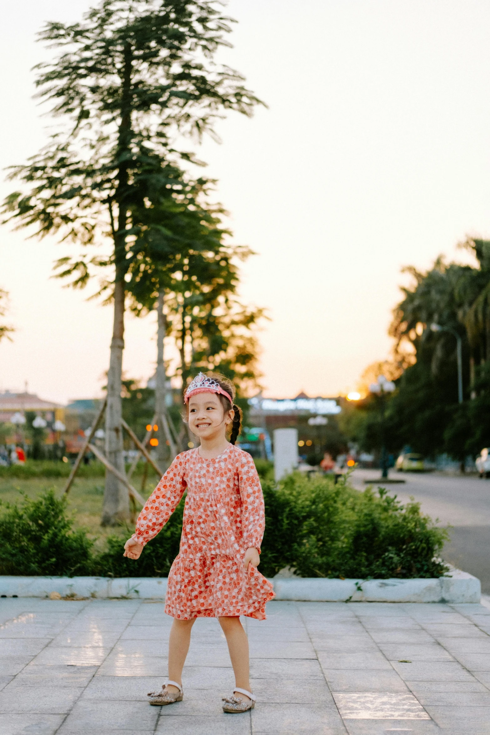 a little girl with a pink flowered headband and her red dress