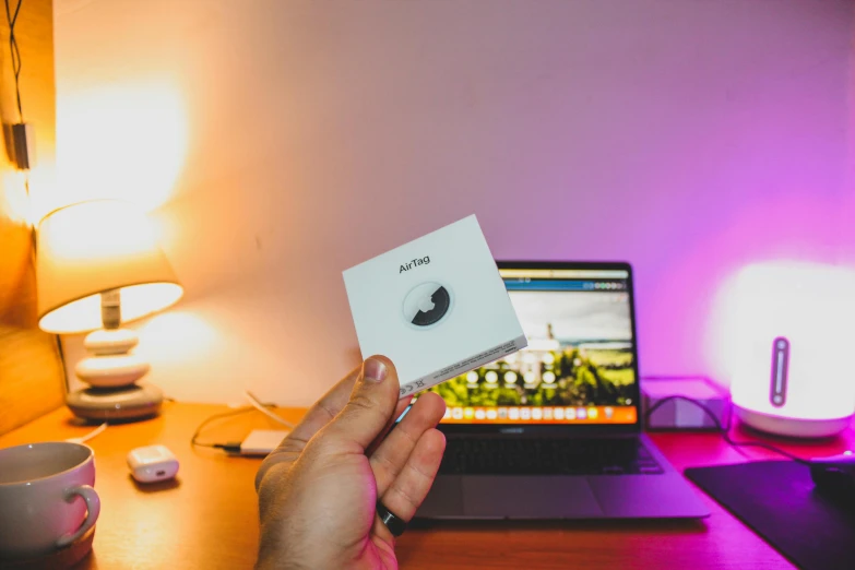 a person holding a card in front of a laptop computer