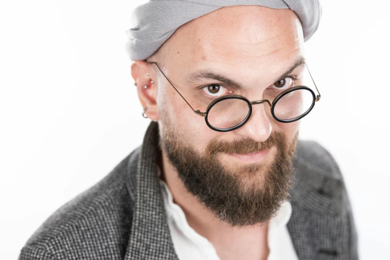 a man in glasses and a hat, looks to his left