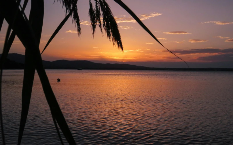 a beautiful sunset reflecting off the waters in a lake