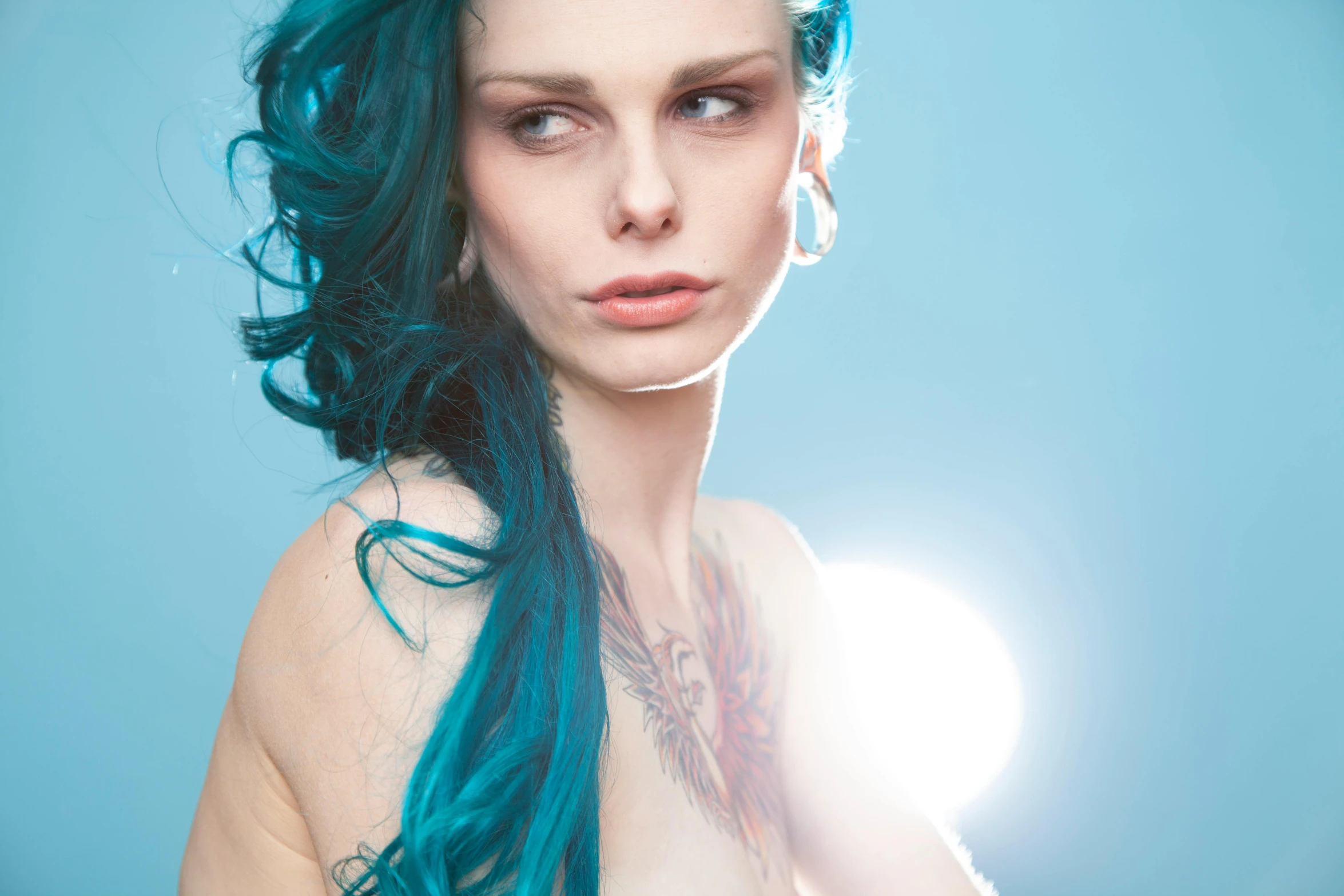 a young woman with blue hair and tattoos