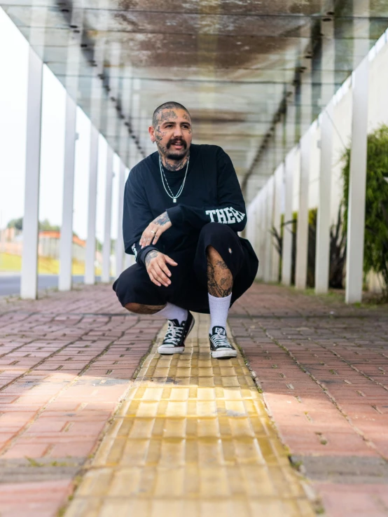 a man kneeling down with a shoe and a beard