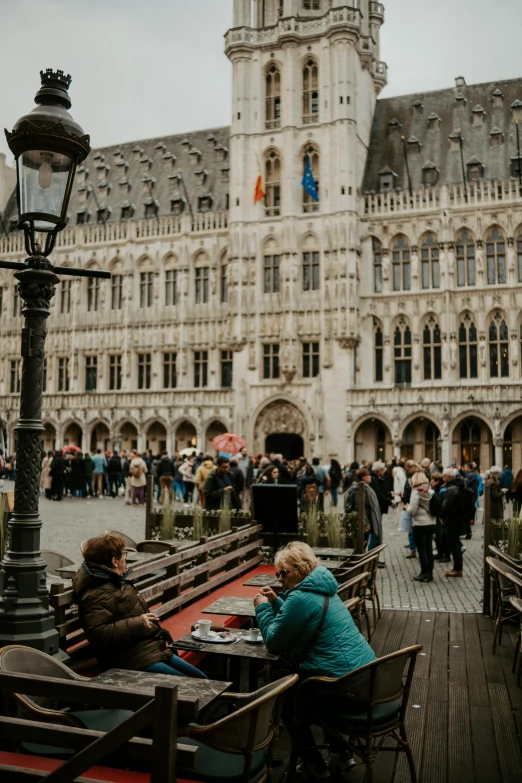 people are sitting outside of a huge building