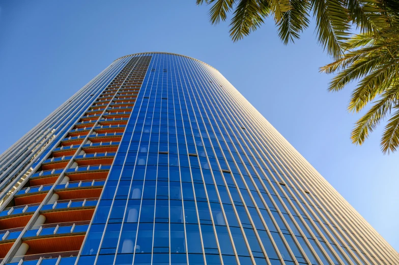 a view of a tall blue skyscr through the glass