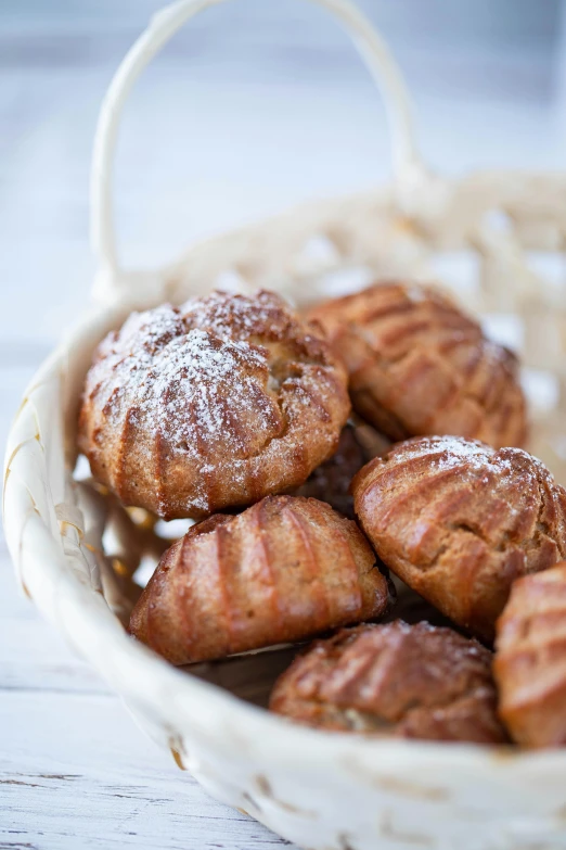 several cinnamon pastries in a basket on top of a table