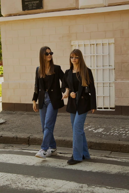 two young women walking down the street together