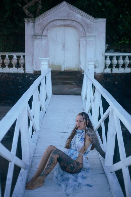 woman sitting on a white bridge with her legs crossed