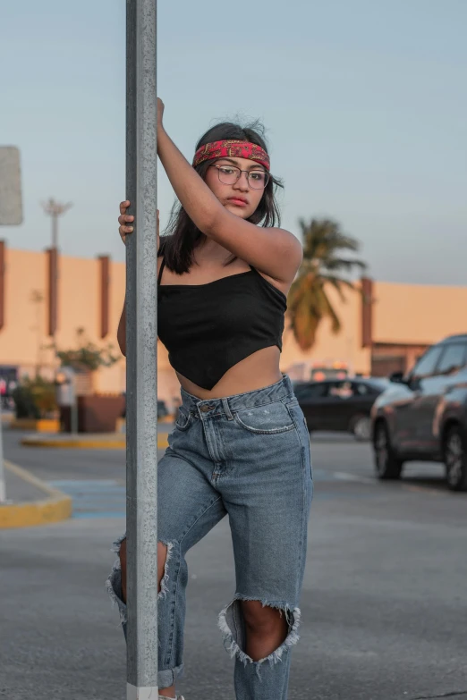 girl leaning against a pole and wearing bandanna