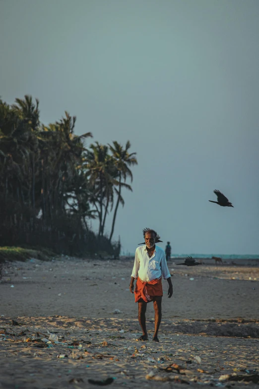 a person walking along the sand near water