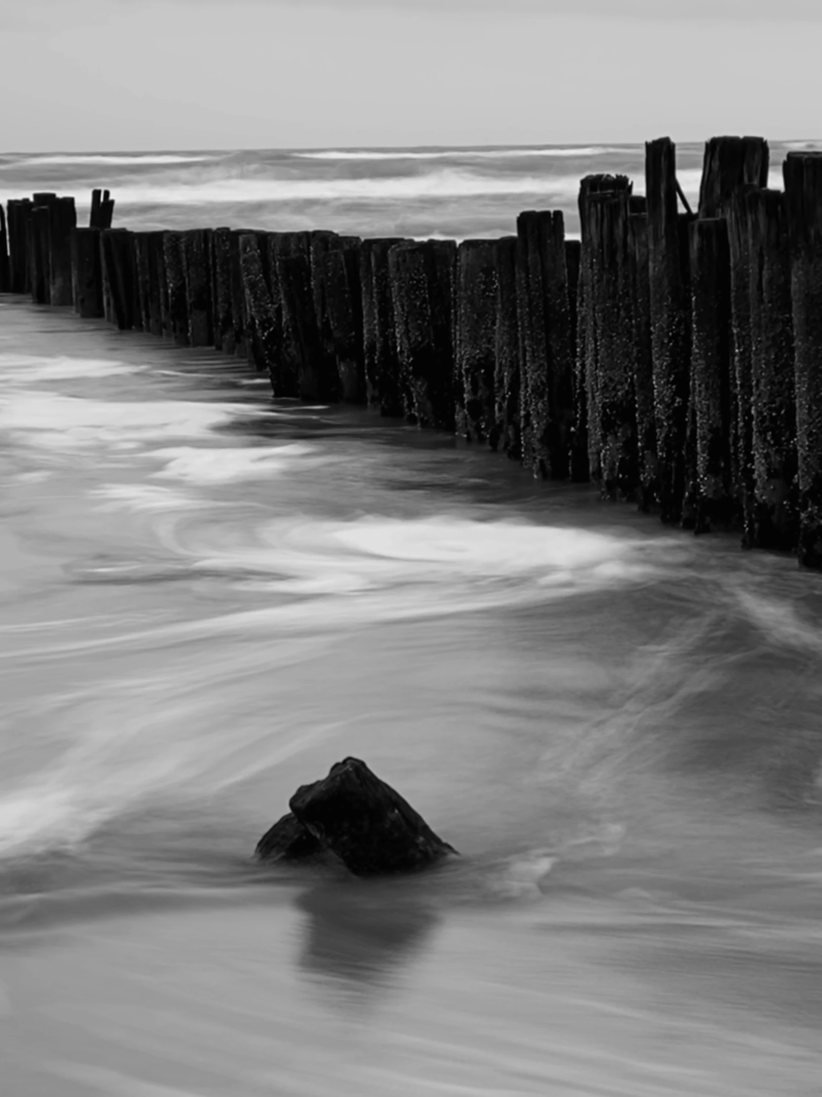 an old wooden fence next to a body of water