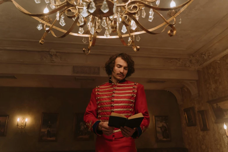 a man in a red uniform holding a book