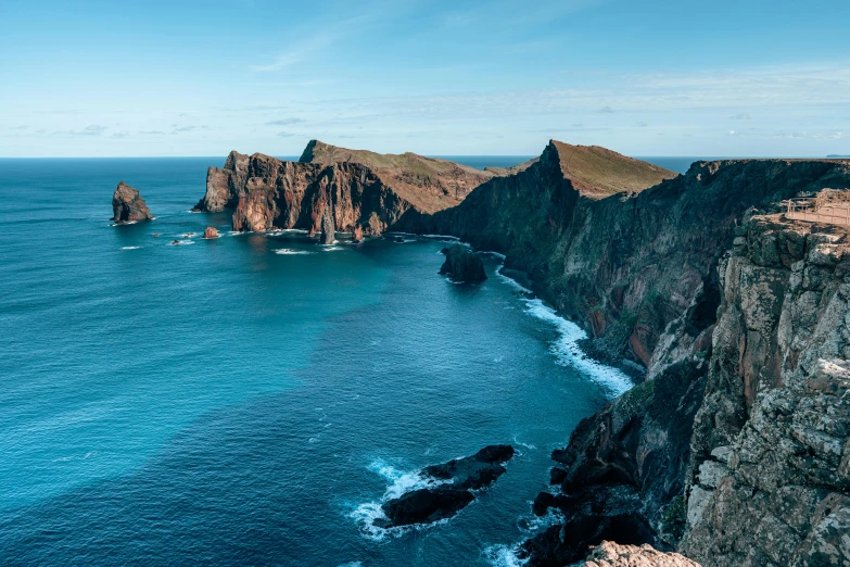 several steep rocky cliff formations with blue ocean water