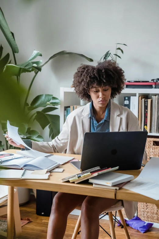 a woman sitting at a desk working on a laptop