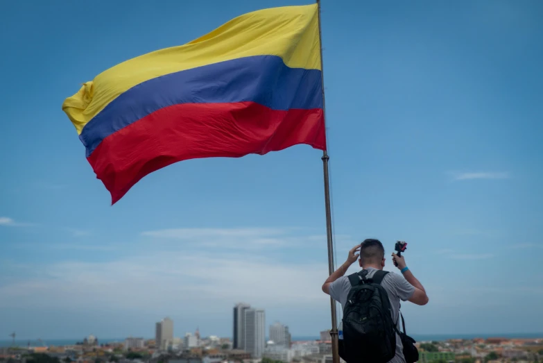 the woman holds the flag high in the sky