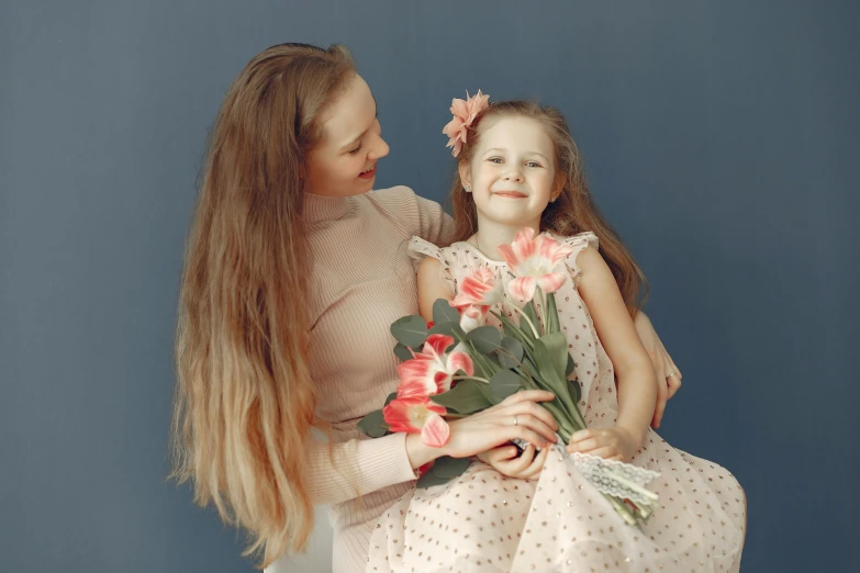 woman and child holding flowers together in their hands