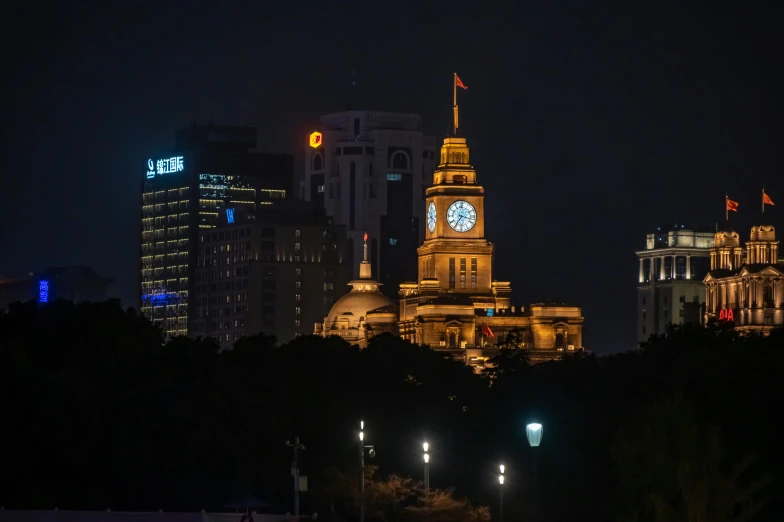 a clock tower stands in the background of a city at night