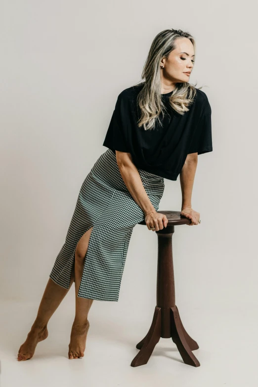 a woman wearing black top standing on the edge of a stool