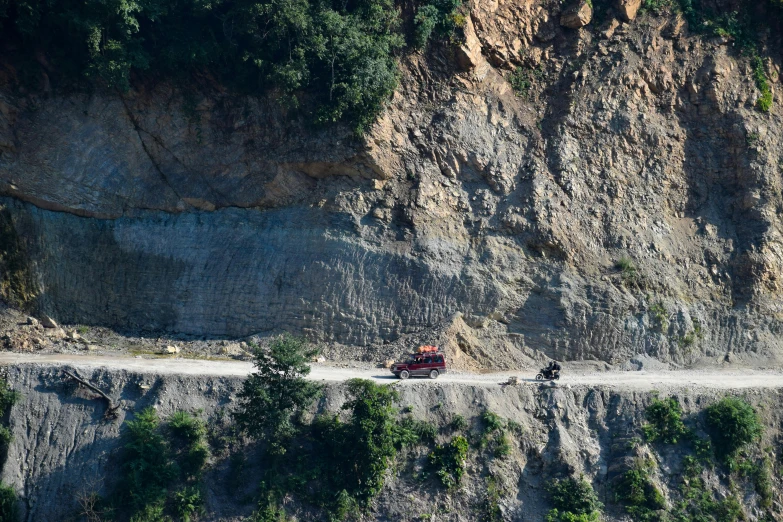 two vehicles traveling down a gravel road