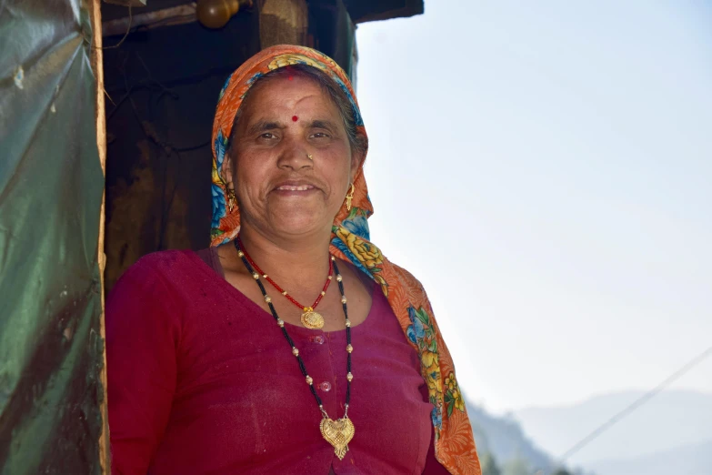 a woman stands outside her home in india