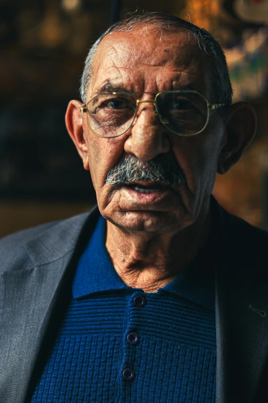 a man wearing glasses and a blue shirt