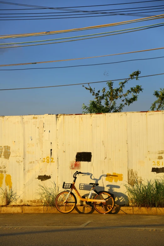 a bicycle leaning against the side of a wall