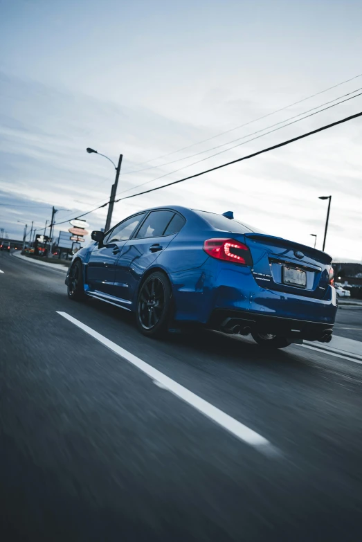 the rear end of a blue car on the road