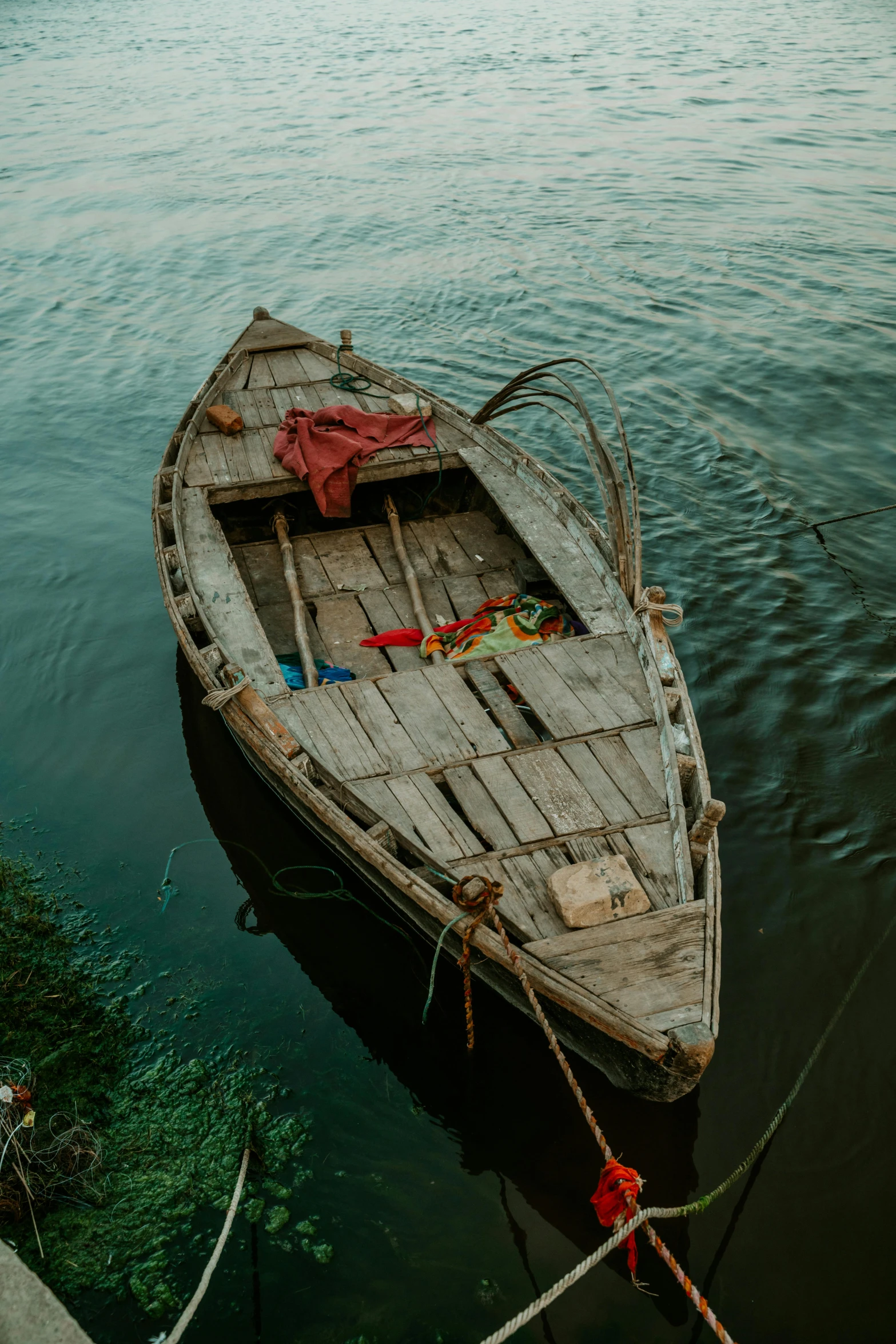 an old boat tied to a dock by rope