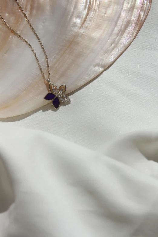 a pearl necklace and a pearl shell on a cloth