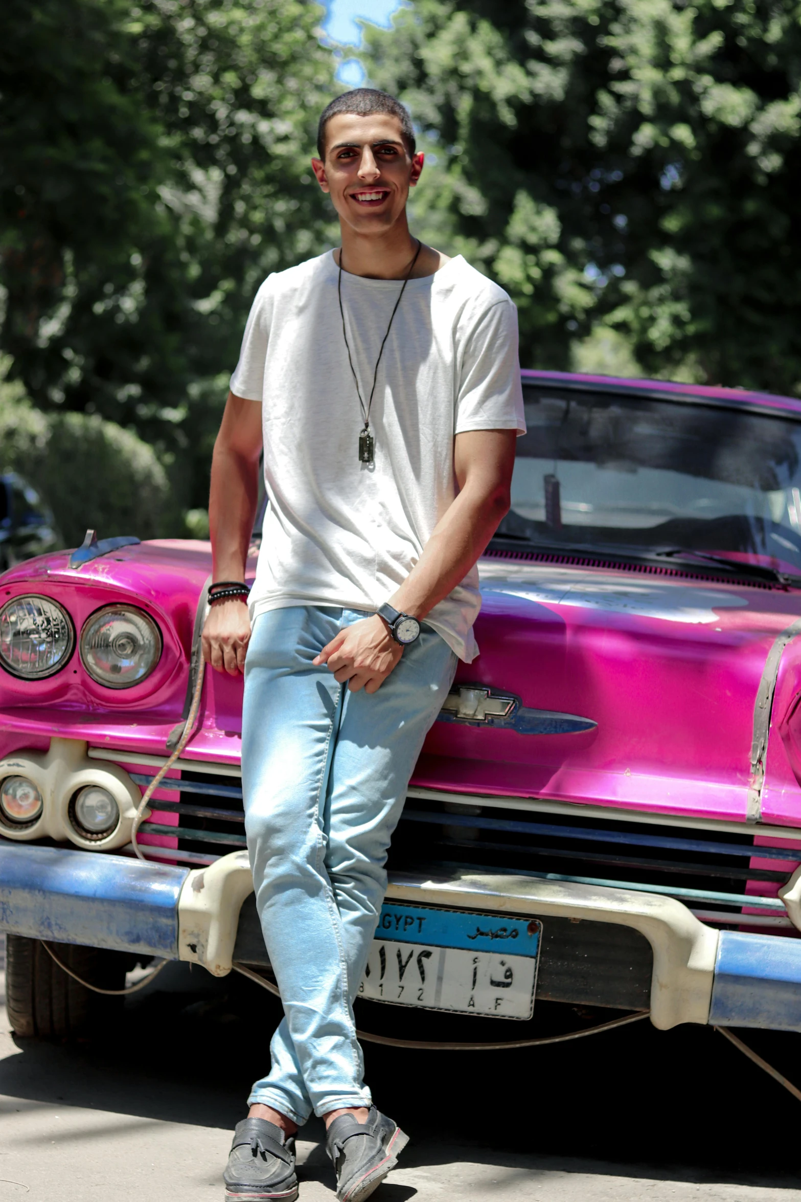 a person leaning on a car and some trees