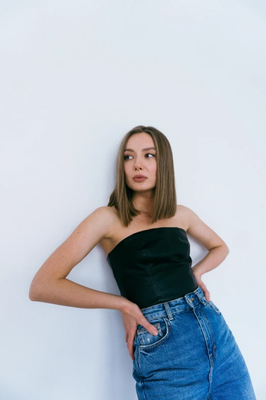 a young woman is leaning against a wall