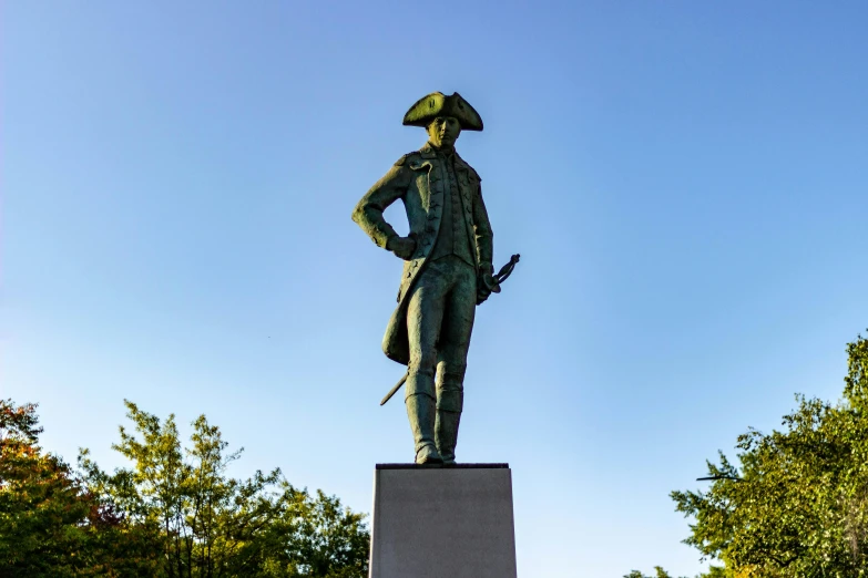 the statue stands tall near many trees