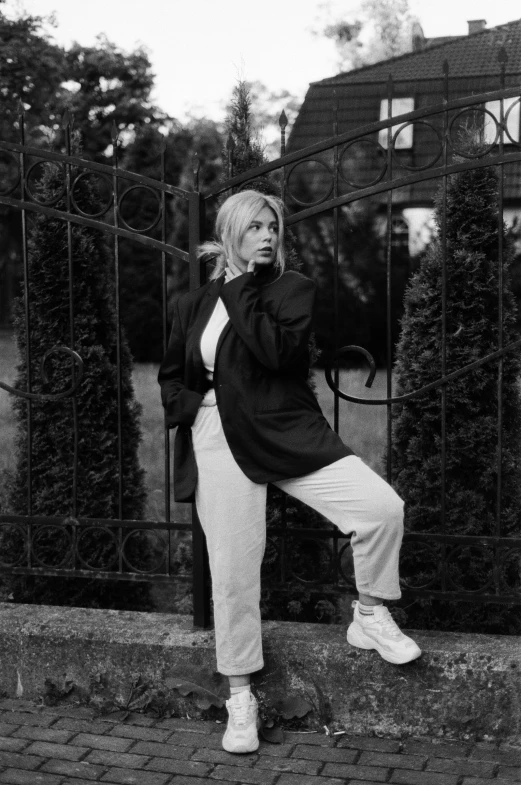 woman standing on brick ground next to a fence