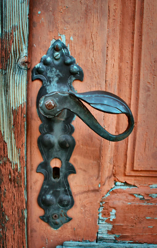 door handle on rusty door with chipped paint and peeling paint