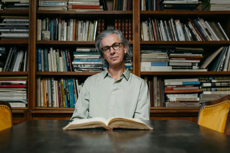 a man sitting at a table with an open book in front of him