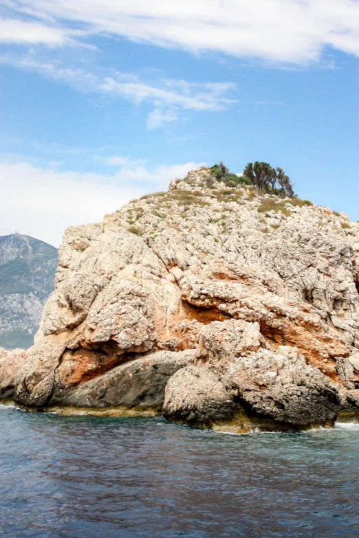 a very large rocky mountain with trees on top