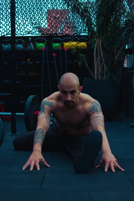 a man with arm tattoos sitting on the ground