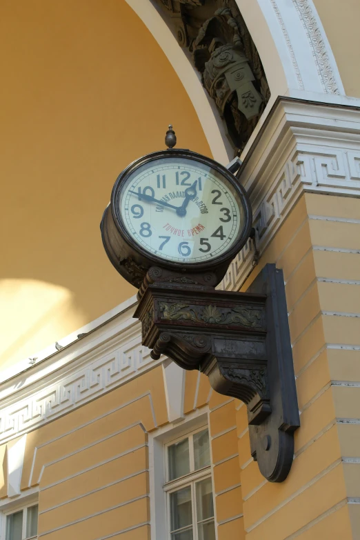 clock mounted on side of building with arched doorway