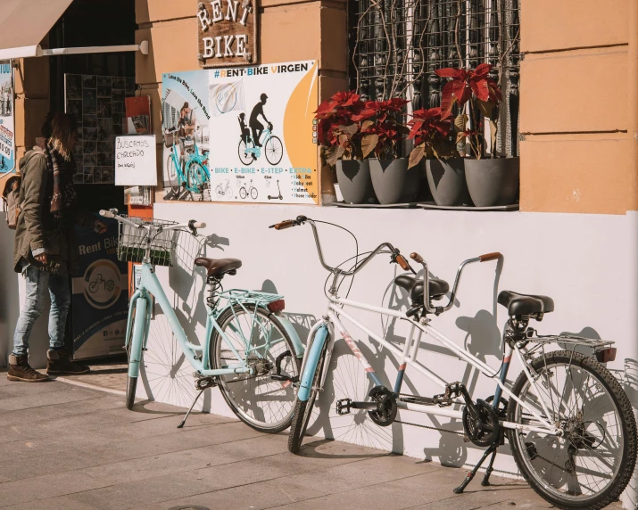 three bicycles lined up in front of a bike shop
