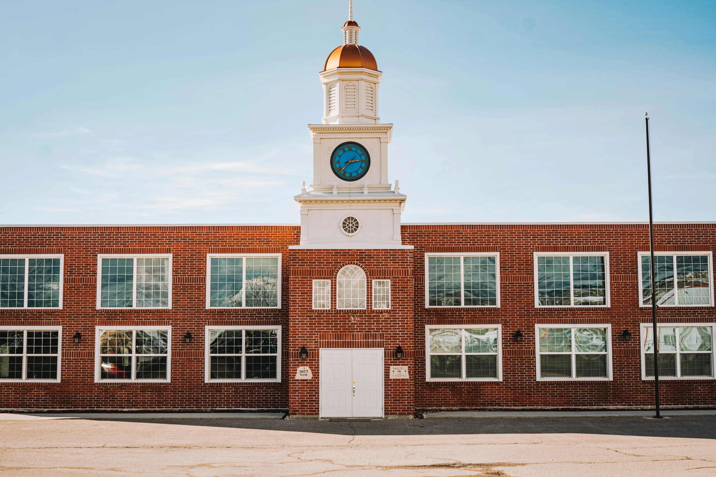 a brick building with a clock tower and weather vane