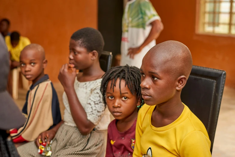 four children sit side by side in a group