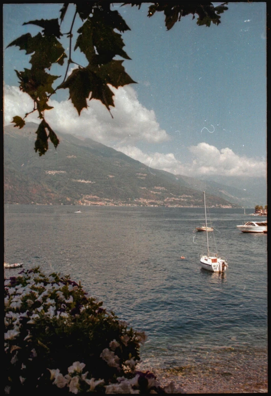 a boat sitting on top of the water next to a hill