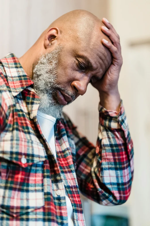 a bald man with a white beard wearing a red and blue shirt