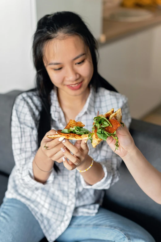 a woman is taking a bite from her pizza