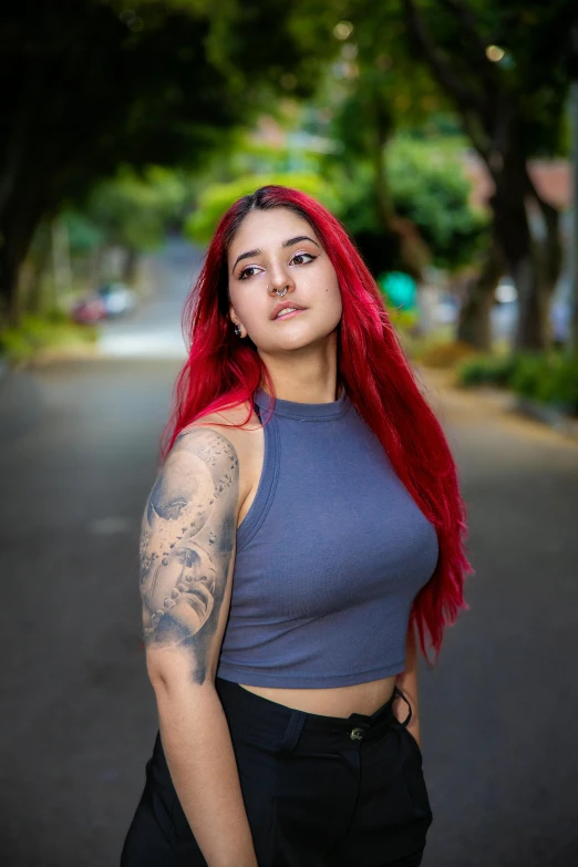 a girl with red hair with a crop top and black pants on the street