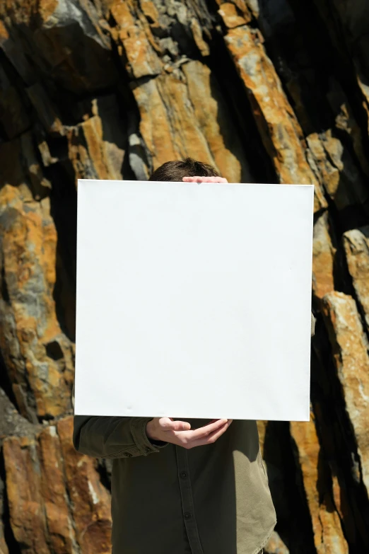 a person with his face obscured by a paper