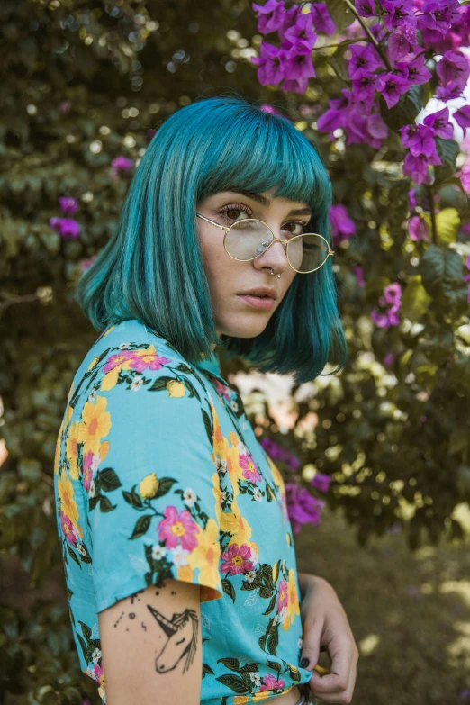 a young woman with bright blue hair and a flower covered face