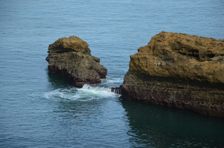 a couple of large rocks sticking out of the water