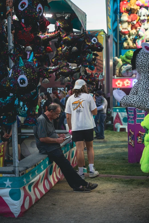 people standing near carnival booths with an animal on display
